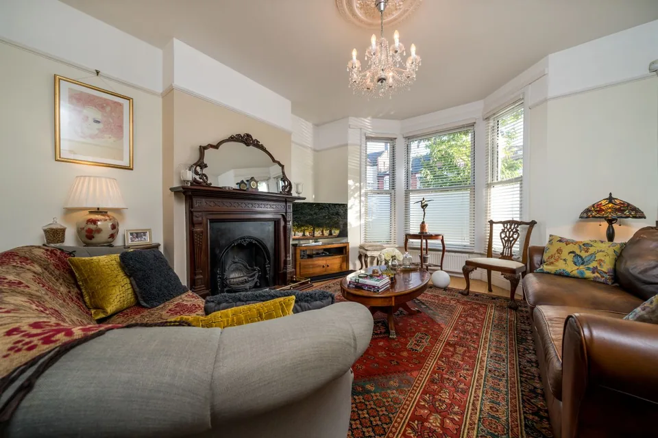 A traditional sitting room with upholstered seating and a chandelier.
