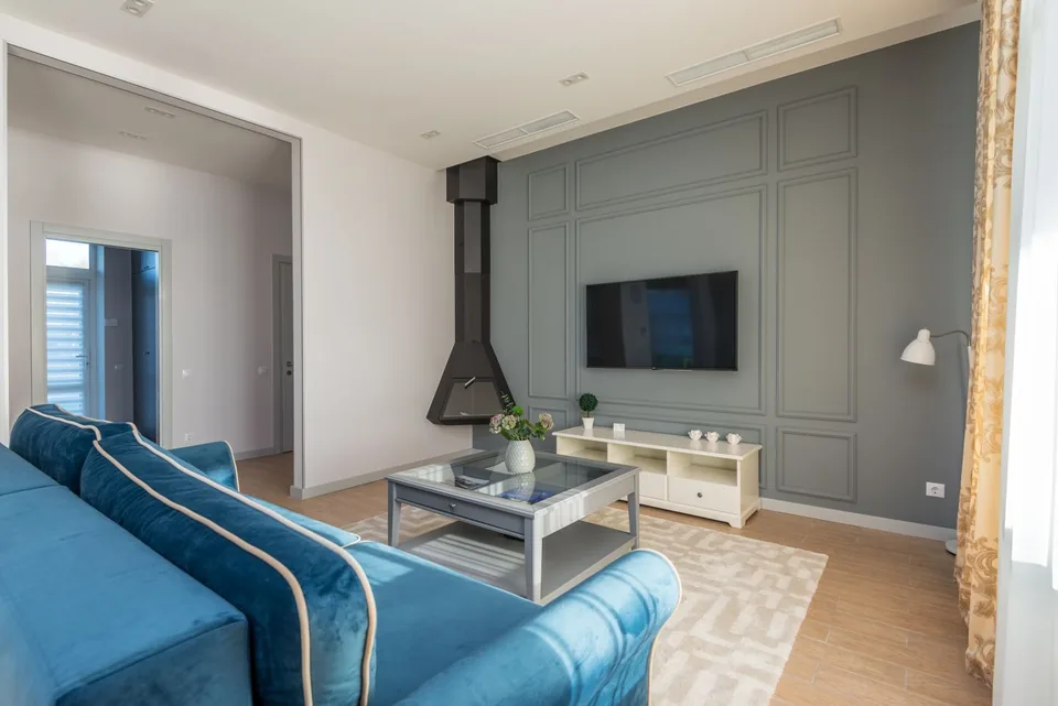 A domestic sitting room with a blue sofa and a television.