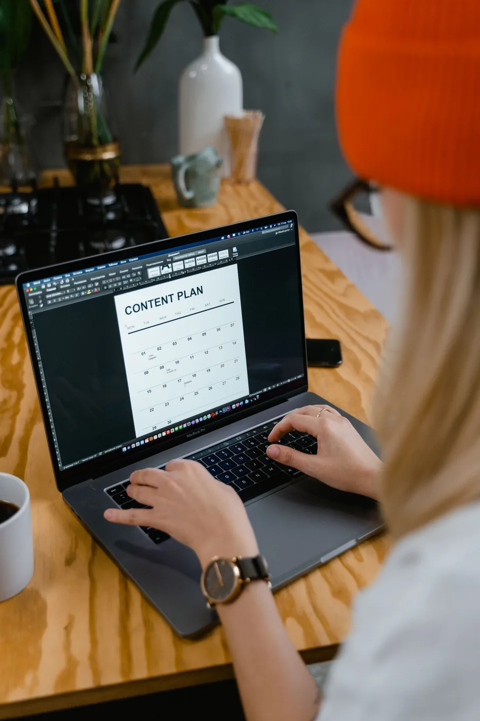 A person working on a laptop at a desk.